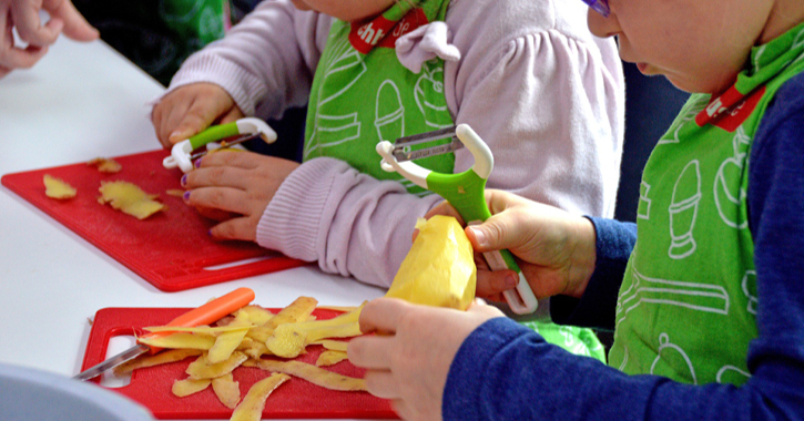 children cooking at home and peeling potatoes. 